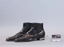 Sko av typ boots av svart lackskinn.