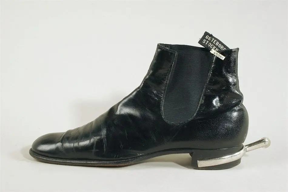 Sko av typ boots av svart lackskinn.