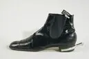 Sko av typ boots av svart lackskinn.